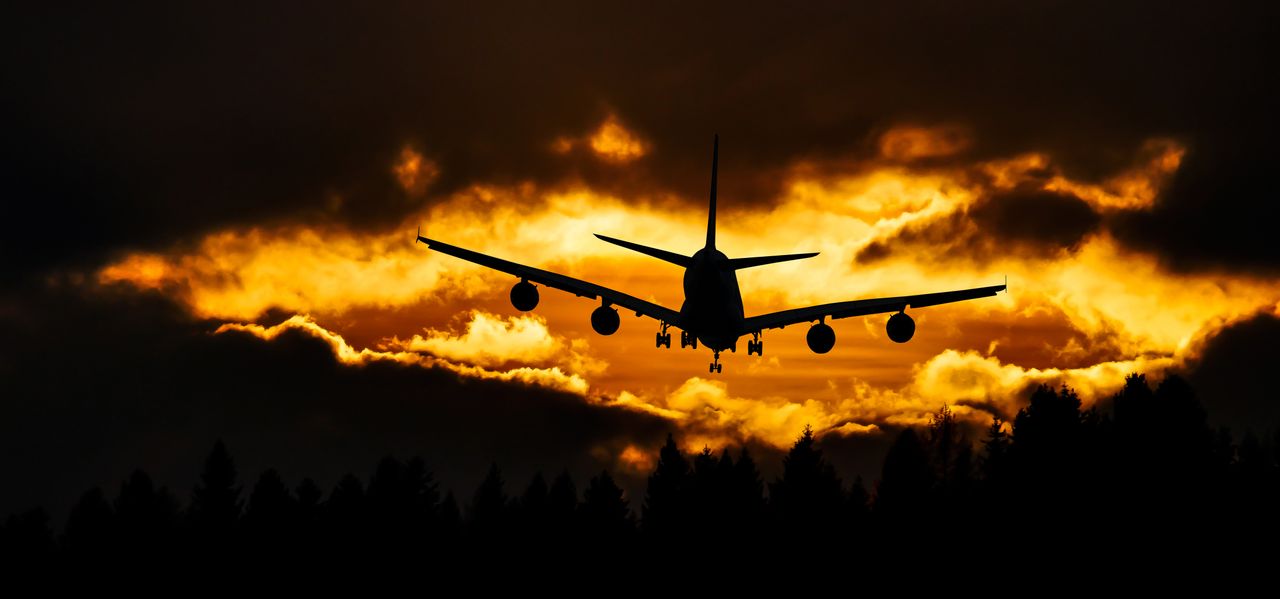 services-02 Airplane silhouette glides through a dramatic sunset sky, creating a striking aviation scene.